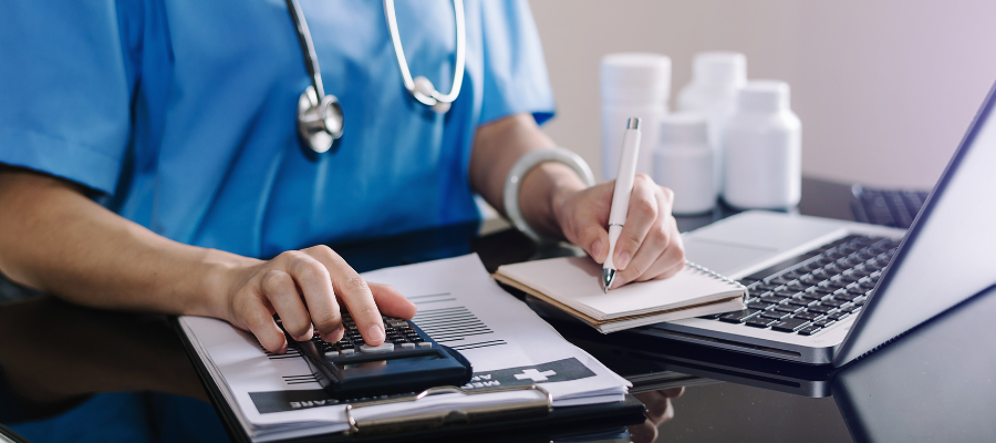 Medical professional going over finacial documents with calculator